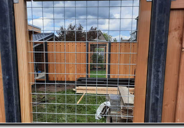 Nieuwe betonschutting in de kleur antraciet met douglas tuinschermen en gaaspanelen