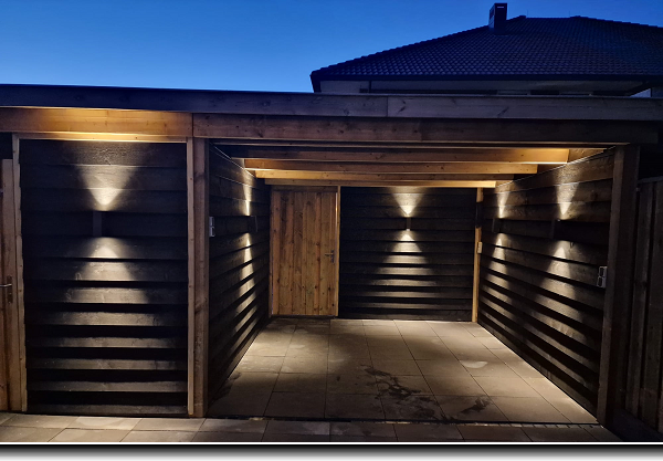 Overkapping met berging van grenen met zwarte potdeksel planken en witte up and down verlichting