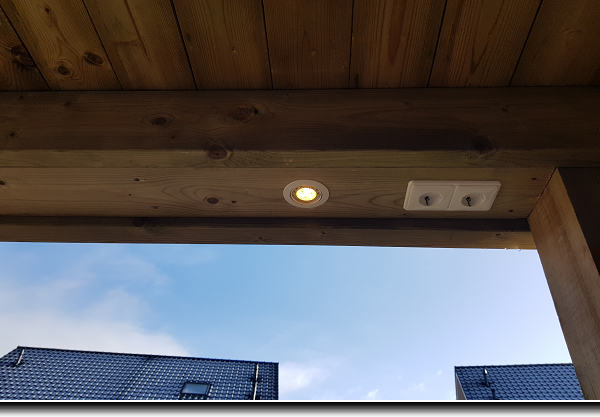 Aanbouw van een douglas overkapping met een plat dak aan een bestaande berging