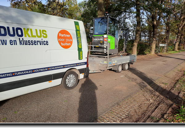Overkapping met berging van grenen met zwarte potdeksel planken en witte up and down verlichting