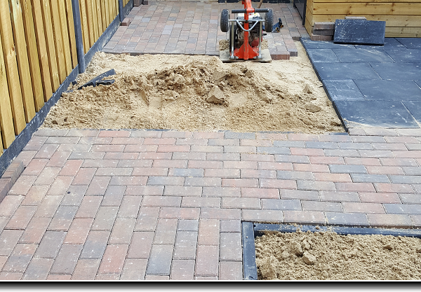 Straatwerk achtertuin van gekleurde betonklinkers en zwarte terrastegels