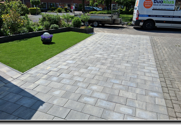 Oprit van kleinere grijze betontegels 